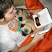 Photo of boy reading with two pugs