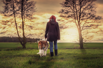 woman walking dog into the horizon